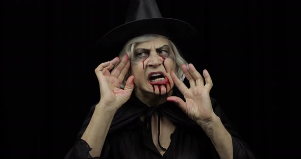 Old Witch Halloween Makeup. Elderly Woman Portrait with Blood on Her Face.