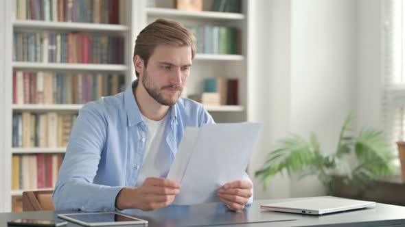 Successful Man Reading Documents at Work