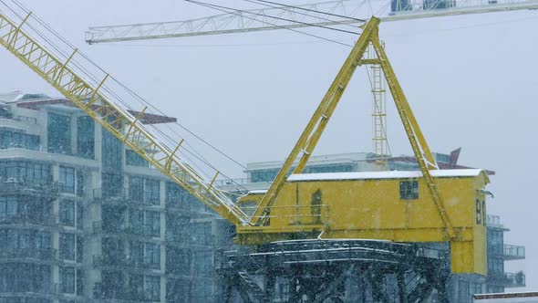 Crane Near Buildings In Heavy Snowfall