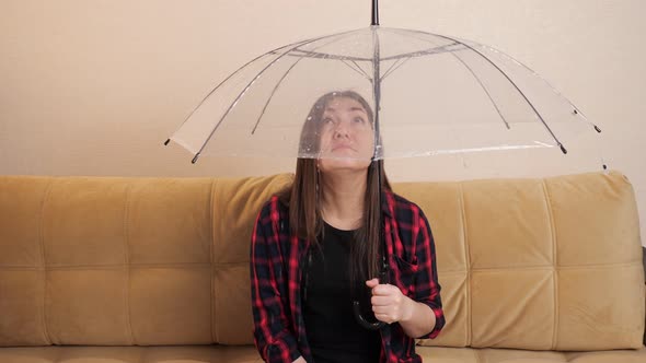 Pensive Woman Hides From Flowing Water Under Clear Umbrella