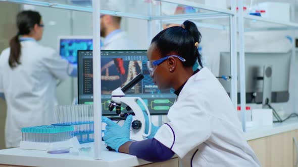 African Woman Scientist Using Microscope in Modern Lab