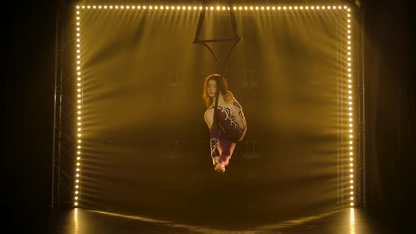 Aerial Acrobat in the Ring. A Young Girl Performs the Acrobatic Elements in the Air Ring. Shot in a