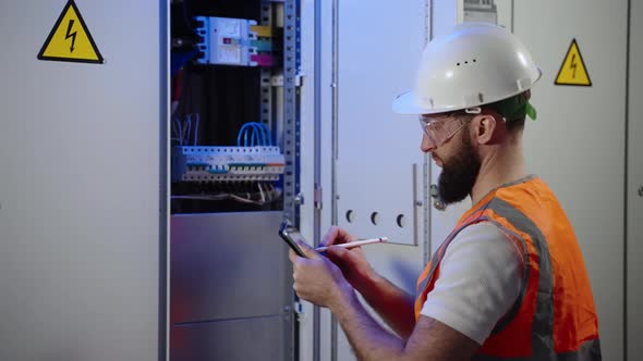 Electrician Providing Checkup of Equipment at Power Station