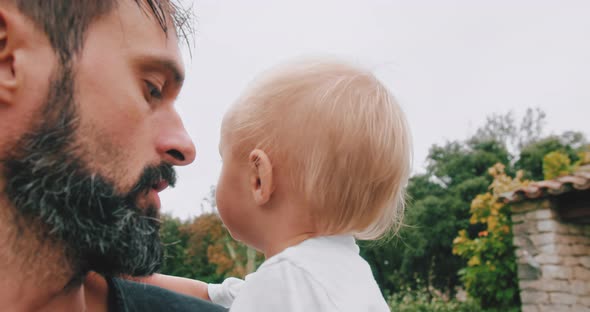 Bearded Young Father Holding in Hands His Cute Little Son