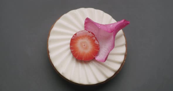 Shot of Tasty Sweet Round Dessert with White Cream Strawberry and Rose Petal