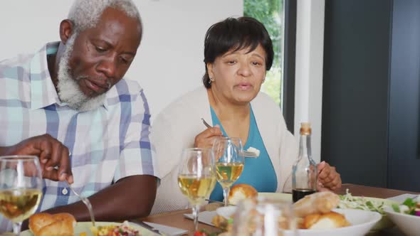 Happy senior diverse people having dinner at retirement home