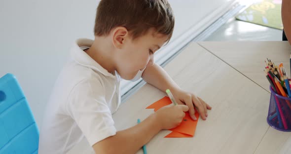 Little Cute Boy Draws with Pencils Is Engaged in Creativity at Home or in Kindergarten, Preparation