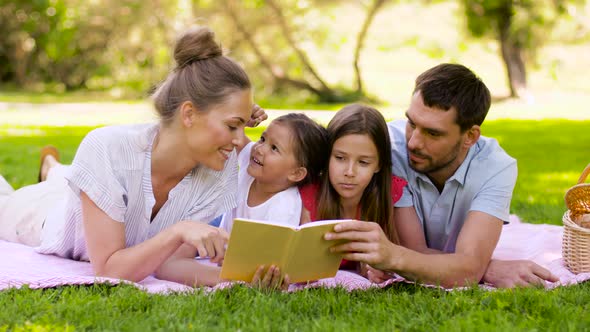 Family Reading Book on Picnic in Summer Park