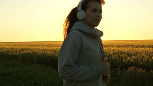 Healthy Beautiful Girl Doing Fitness Jogging on a Wheat Field. Training Run. Free Young Woman Runs