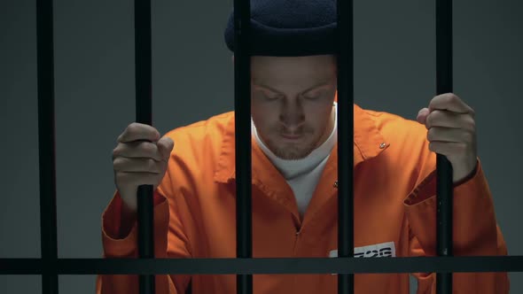 Prisoner Holding Bars and Leaning Head, Feeling Depressed, Psychological Rehab