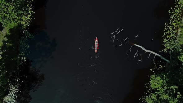 Aerial Flight Over Two Men Rowing in a Red Kayak