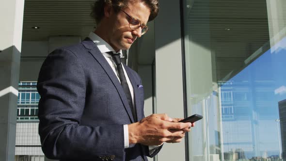 Businessman on smartphone in a modern office building