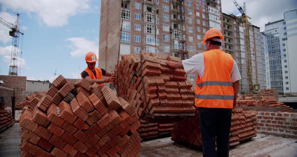 Construction Workers Attach Materials To the Crane