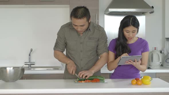 MS Young couple in kitchen standing and preparing food