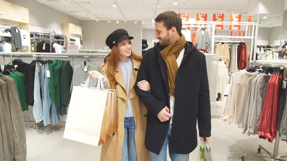 Cheerful Happy Married Couple Buy Gifts for Friends in Mall