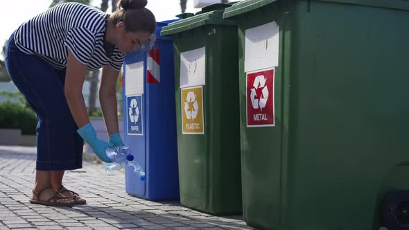 Young Woman in Gloves Picking Empty Water Bottles Putting Trash in Plastic Container for Separate