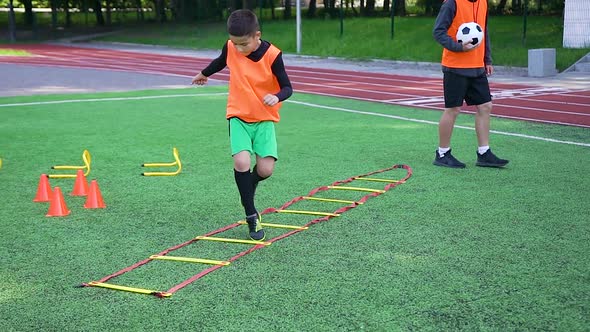 Boy in Football Uniform Doing Running and Jumping Exercises on Ladder During Work Out