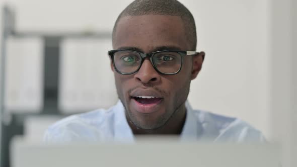 Close Up of African Man Celebrating While Using Laptop