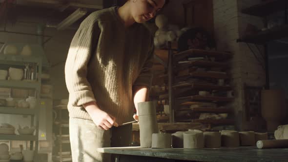 Woman Potter Is Cutting Off Clay Pieces