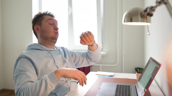 The Guy Works at the Computer All Day Tired Yawns Looks at the Clock