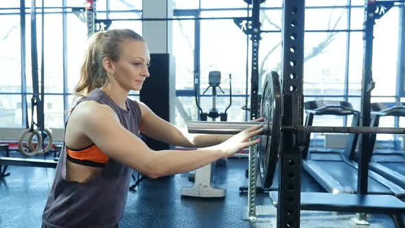 Young fitness woman getting ready for weights lifting exercise.
