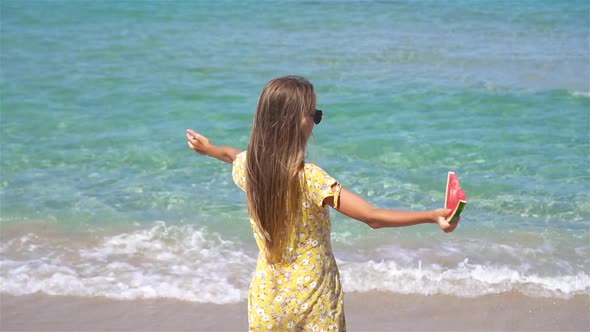 Happy Girl Having Fun on the Beach and Eating Watermelon