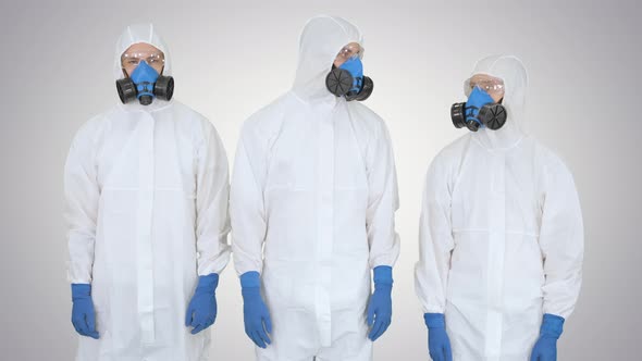 Team of Scientists or Doctors in Protective Suits Ready for Work Crossing Hands on Gradient