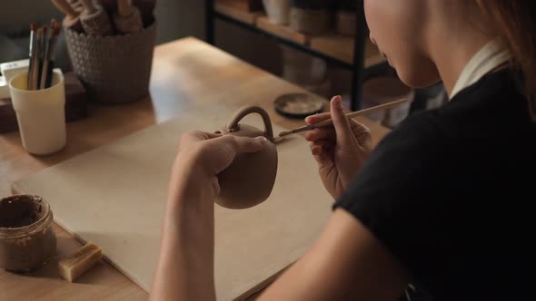 Front View of Female Potter Kneading Softly Clay on Worktop with Her Hands