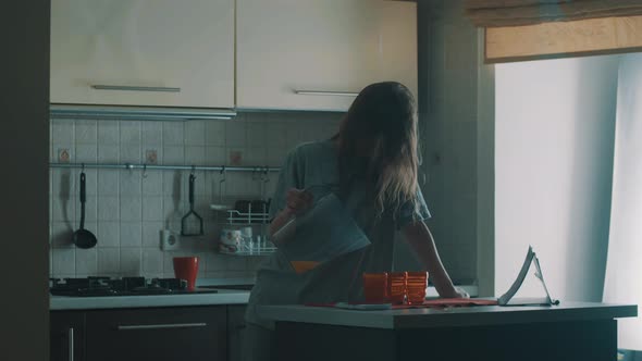 Clumsy Drowsy Young Girl Pour Juice Into Red Glass Slips and Fall Over