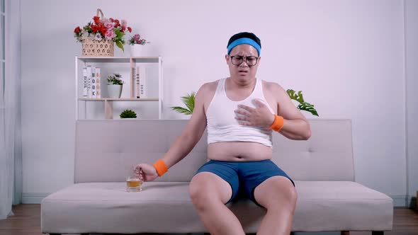 Fat Asian man in sportswear get heart attack after drinking alcohol