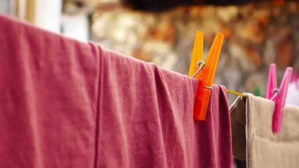 A Man Hand Detaches a Clothespin From Clothes Drying Outdoors in Closeup