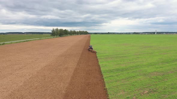 Tractor With Plow Plows In Spring Of Agricultural Field Before Planting Crop