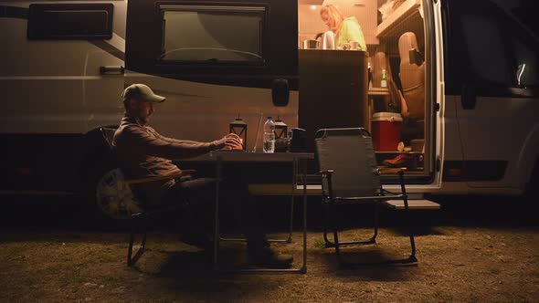 Modern Couple Staying Overnight in the RV Park with Their Camper Van