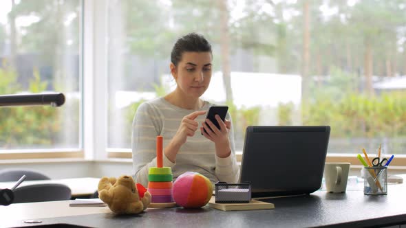 Young Woman with Smartphone Working at Home Office