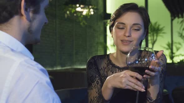 Gorgeous Dark Haired Woman Drinking Wine During the Date with Her Boyfriend