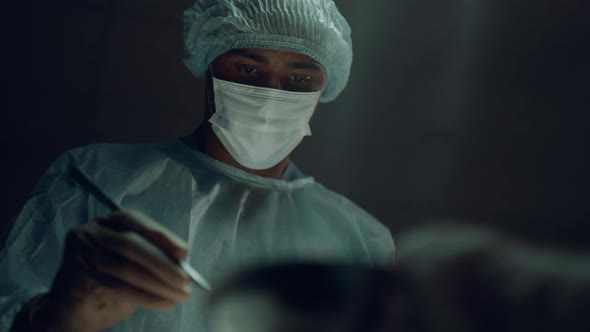 Portrait African American Surgeon Performing Surgical Operation in Clinic Room