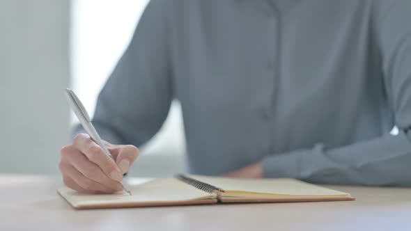 Close Up of Woman Writing on Notebook