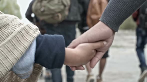 Woman and Child Holding Hands and Walking