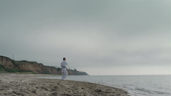 Sportsman Training Karate Exercises on Beach