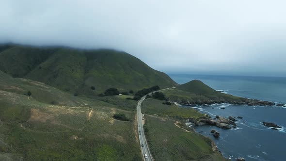 Aerial footage, cars driving by the ocean, mountain top in the fog at Garrapata, California, USA
