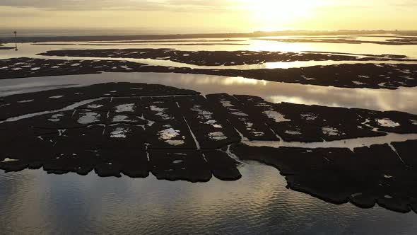 An aerial shot over Baldwin Bay near Freeport, NY at sunset. The camera dolly out from the sun as it