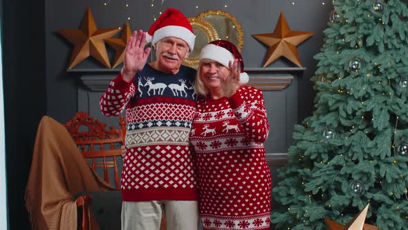 Happy Senior Christmas Family Smiling Friendly at Camera and Waving Hands Gesturing Hello or Goodbye