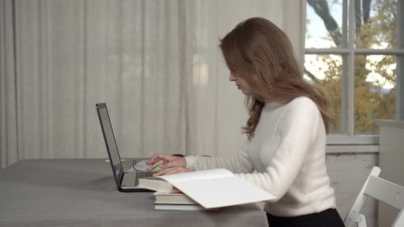 Young Woman Student Studying at Home with a Laptop