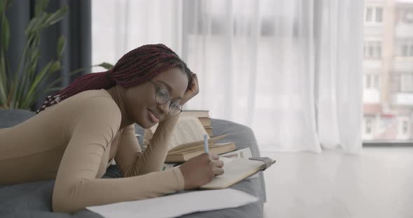 Black Race Girl Studying While Lying in Bed