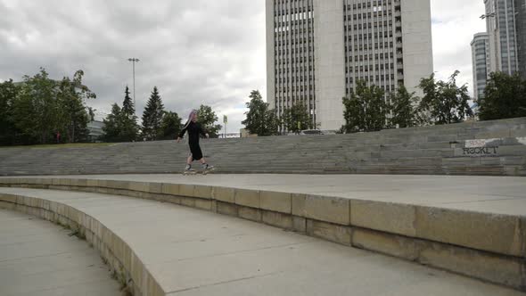 Video of an Interesting Girl with a Bright Appearance Who Skates Around the City