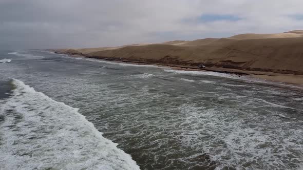 Beautiful wavy Atlantic ocean and huge sand dunes, Sandwich Harbour, Namibia