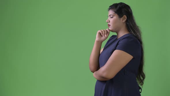 Young Overweight Beautiful Indian Businesswoman Against Green Background