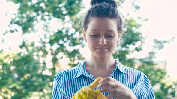 Pretty Lady in Blue White Shirt Puts on Yellow Rubber Gloves