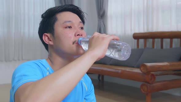 Man Drinking Water After Exercises At Home