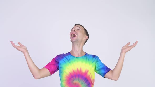 Studio Shot of Happy Man with Tie-dye Shirt Catching Something